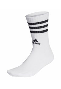 Calcetín deportivo blanco con textura acanalada, que presenta tres franjas horizontales negras en la parte superior y un logo negro de Adidas cerca del tobillo.