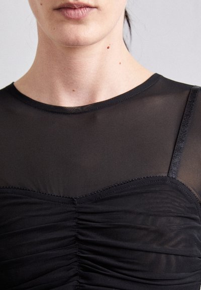 Sort med en tettsittende design med en gjennomsiktig øverste del, rynking ved bysten og en tynn, blank stropp prydet med sømdetaljer.