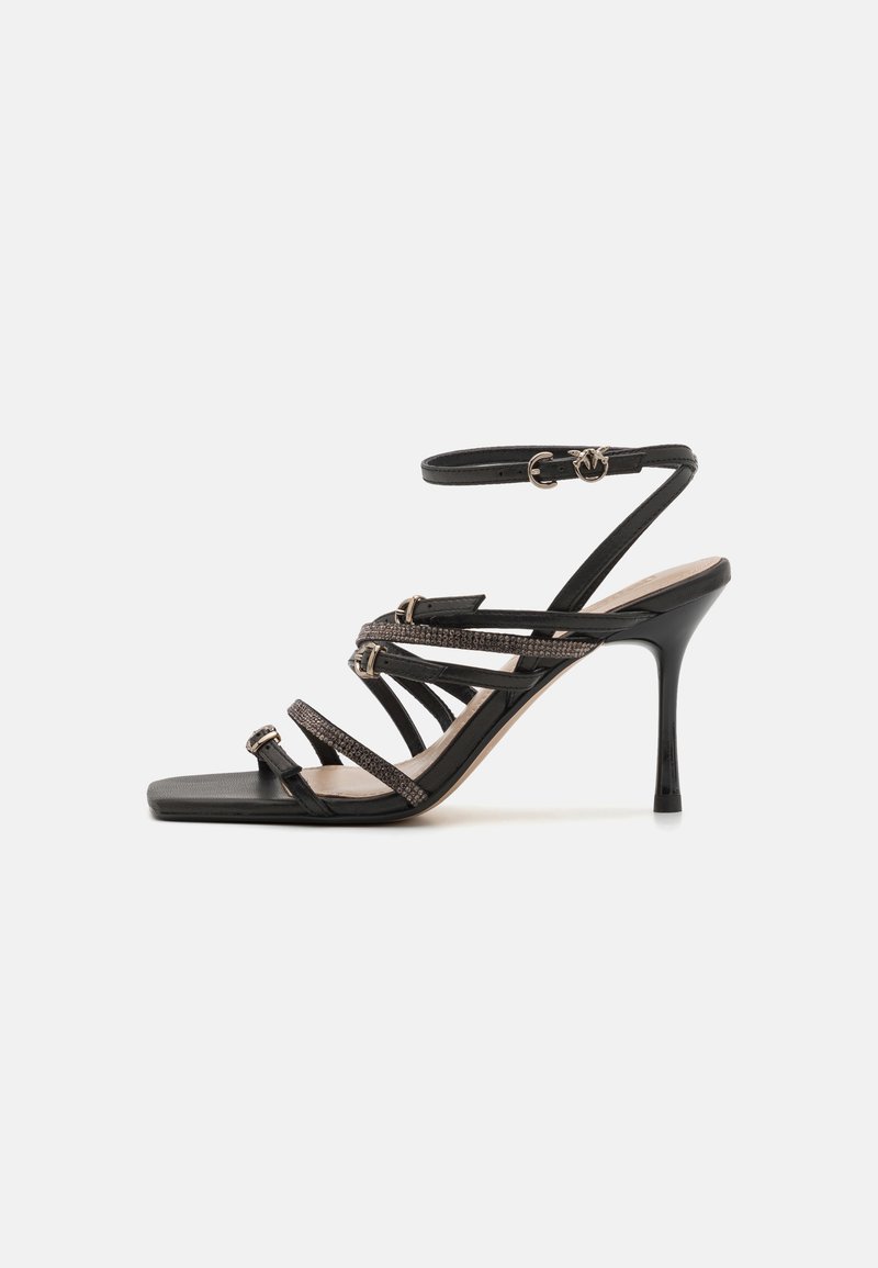 Black high-heeled sandals feature multiple slender straps, a square toe, and metallic accents on the front. Adjustable ankle strap included.