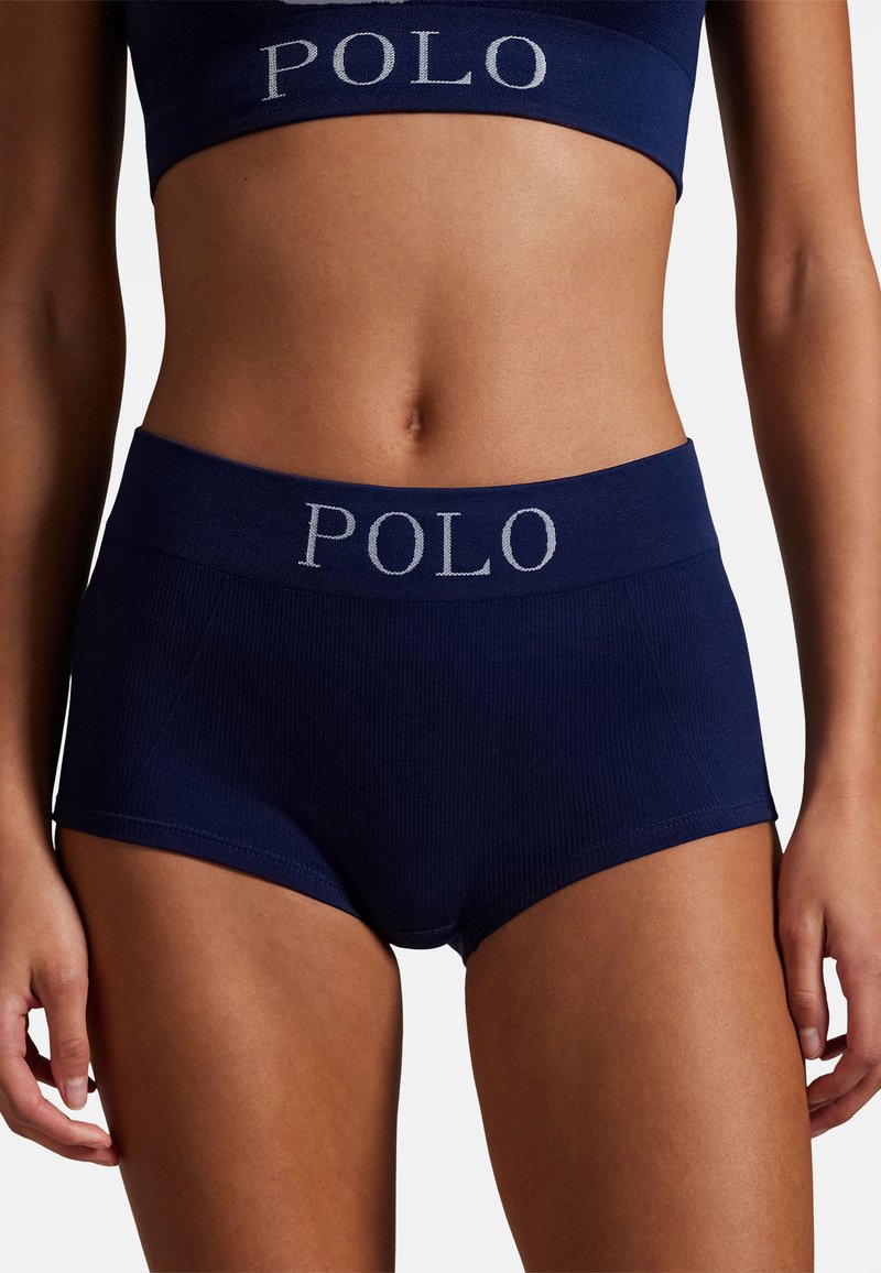 Set di bralette e pantaloncini in cotone costellato blu navy con una fascia larga in vita con il logo "POLO" in grigio chiaro. Texture liscia, design aderente.