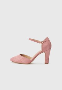 Chaussure à talon aiguille en daim rose avec un bout pointu et une sangle à la cheville dotée d'une boucle en or. Tige texturée et design de talon solide.