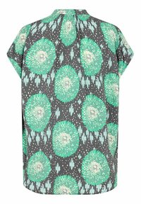 Koszulka z krótkim rękawem w ciemnoszarym kolorze z dużymi, zielonymi okrągłymi wzorami i jasnymi akcentami. Materiał ma gładką fakturę i luźny krój.