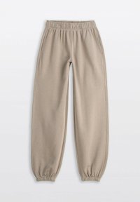 Beżowe klasyczne dresy z elastycznym pasem i mankietami, z bocznymi kieszeniami, ułożone na jasnym tle.