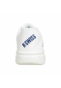 Zapatilla deportiva blanca con parte superior de malla texturizada, suela de goma y logo azul de "K-SWISS" en el lateral. Tacón redondeado con diseño de soporte.
