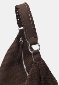 Braune geflochtene Handtasche mit einer strukturierten Wildleder-Oberfläche, ausgestattet mit einem geflochtenen Griff, silbernen Beschlägen und einem sichtbaren Reißverschlussdetail.