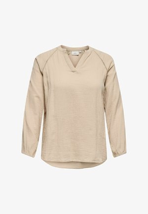 Beżowa bluzka z długim rękawem w kształcie litery V, wykonana z fakturowanej tkaniny, z opadającymi ramionami i subtelnymi detalami stębnowania wzdłuż szwów. Lekko zaokrąglony dół.