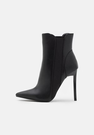 Schwarze Lederknöchelstiefel mit spitzer Zehenpartie, hohen Stiletto-Absätzen und elastischen Seiteneinsätzen für eine enge Passform. Glatte Textur und minimalistisches Design.