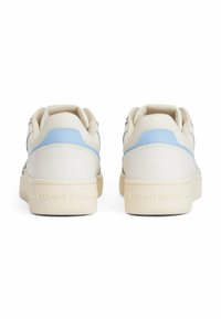 Witte sneakers met lichtblauwe accenten, gemaakt van glad leer, met een gestructureerde achterkant, ronde neus en "TOMMY JEANS" branding op de hiel.