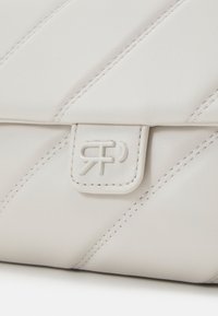 Bílá kožen�á taška s diagonálním švem, obsahující magnetické zavření a malé vyražené logo na přední straně. Hladká textura.