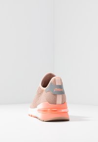 Ljust rosa stickade sneakers med en texturerad ovandel, vit mellansula och orange detaljer. Har en logotyp på hälen och en vadderad sula.