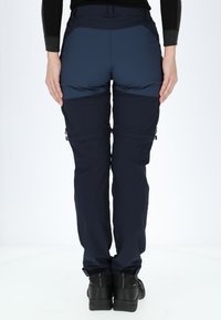 Navy blue outdoor pants with contrasting upper panel, zippered side pockets, and adjustable cuff details. Made from a lightweight, durable fabric.