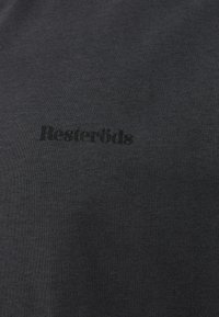 Sorte bomulds t-shirt med en blød tekstur. Har et synligt "Resteröds" logo trykt i mørkegrå, centreret på brystet.