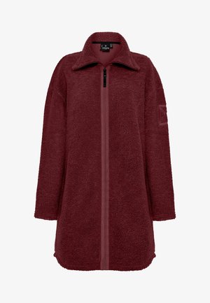 Burgundyröd fleecejacka med hög krage, dragkedja framtill och sidofickor. Har en texturerad, mjuk yta och avslappnad, lös passform.