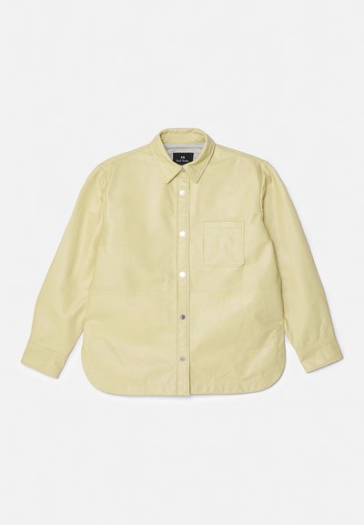 Cămașă lungă cu mâneci, de culoare galben deschis, cu guler tip button-down, buzunar în față și închizători cu capse, având o textură netedă și o croială lejeră.