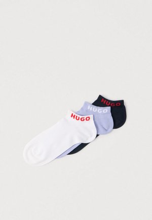 Three pairs of ankle socks: white with red logo, light purple with gray logo, and dark navy with red logo. Cotton blend, smooth texture.