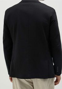 Black tailored blazer featuring a notch lapel, single vent, and four-button cuffs, made from a smooth fabric with a matte finish.