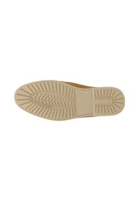 Semelle d'une chaussure marron avec un motif en caoutchouc beige comportant des rainures diagonales et droites pour l'adhérence et le mot "SOLO" embossé près de la voûte plantaire.
