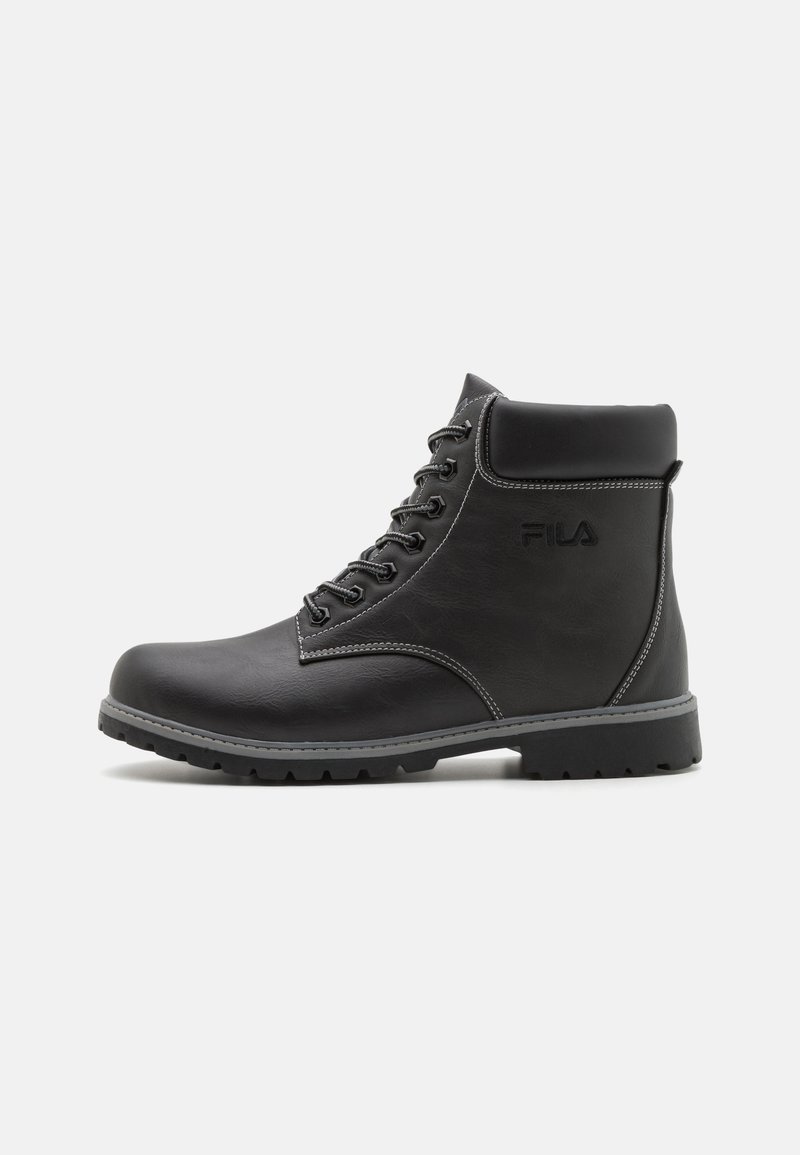 Bottine noire en cuir à lacets avec col rembourré, semelle robuste et logo FILA discret sur le côté, sur fond uni.