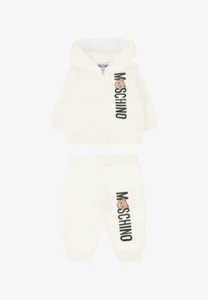 Witte trainingspakset met een rits-hoodie en broek. Bevat zwarte "Moschino" tekst en een beer graphic. Gemaakt van zachte, rekbare stof.