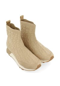 Botines beiges con un empeine de punto texturizado, logotipos en relieve, puños elásticos y una suela blanca en contraste.