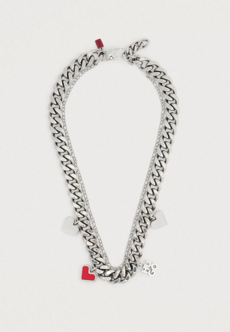 Hõbedast kett-kaelakee, millel mitu kihti, punaste ja hõbedaste südametega ripatsid ning mänguline ripats. Läikiv viimistlus, julged lingid.