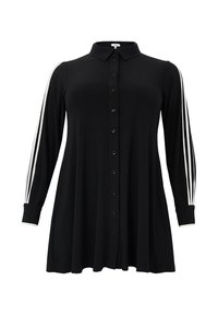 Chemise noire à manches longues, avec des rayures blanches le long des épaules. Fabriquée en tissu doux, avec une coupe décontractée et évasée.