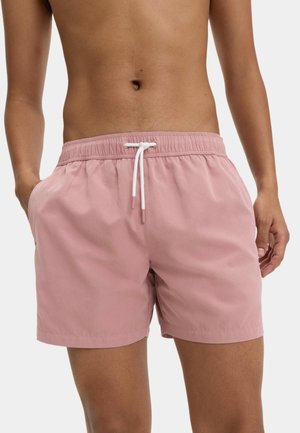 Shorts de bain rose clair en tissu léger, dotés d'une taille élastique avec un cordon blanc et de poches latérales.