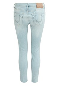 Jeans en denim bleu clair avec une coupe ajustée, comportant deux poches arrière avec des coutures assorties et une étiquette de marque en cuir sur la ceinture.
