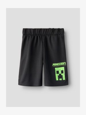 Melni šorti ar elastīgu jostasvietu un neona zaļu Minecraft logo un pikseļotā Creeper sejiņa uz labās kājas.