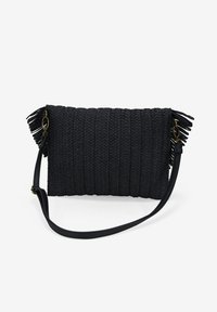 Bolso de mano negro tejido con una superficie texturizada, que presenta detalles de flecos en los lados y una correa desmontable para mayor versatilidad.