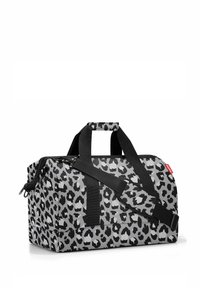 Bolso de lona gris con un patrón de leopardo negro. Fabricado con un material resistente, cuenta con correas y asas negras ajustables para un transporte fácil.