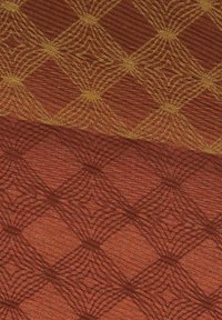 Tissu avec un motif en losanges tissé dans des teintes orange et rouge, présentant une texture subtile et des accents dorés scintillants dans le design.