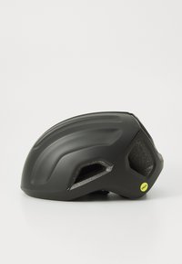 Czarny kask o smukłym, aerodynamicznym kształcie, z teksturowaną powierzchnią i otworami wentylacyjnymi. Zawiera żółtą naklejkę MIPS.