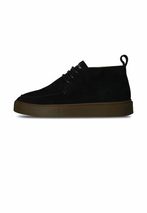 Schwarzer Wildleder-Schuh mit mittelhohem Schaft, brauner Gummisohle, Schnürung vorne und Fersenschlaufe, im Seitenprofil auf weißem Hintergrund dargestellt.