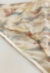 Costumi da bagno a slip con motivo camouflage, realizzati in materiale morbido e trasparente, presentano tonalità pastello di rosa, beige, blu e giallo, con una vita elastica liscia.