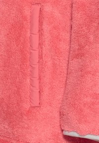 Fuzzy pink fleece jacket featuring a soft texture, a contrasting fabric pocket, and a smooth lining along the edges.