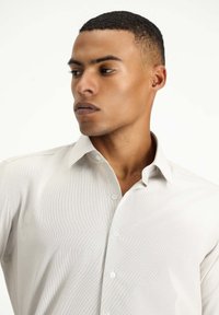 Helles graues Hemd mit Knopfleiste, strukturiertem Finish, Kentkragen und glattem Stoff. Mit weißen Knöpfen und taillierter Passform.