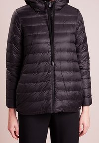 Černá prošívaná bunda s kapucí a zipovým zapínáním, s horizontálním prošíváním. Lehce materiál a elastické manžety.