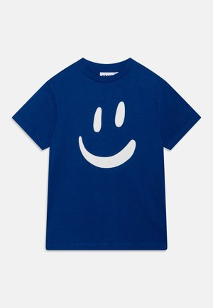 Blå bomulds t-shirt med et stort hvidt smilende ansigt grafisk tryk på forsiden. Klassisk crew neck og korte ærmer.