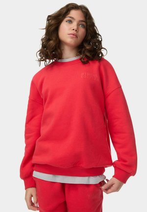 Sweatshirt rouge à col rond, avec des poignets et une taille côtelés. Présente l'inscription "WEEKEND EDITION" imprimée en gris clair sur la poitrine.
