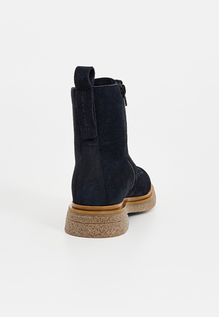 Marineblaue Wildleder-Ankle Boots mit strukturiertem Rücken, schwarzem Reißverschluss und natürlicher Korksohle. Mit einer Zuglasche für einfaches An- und Ausziehen.
