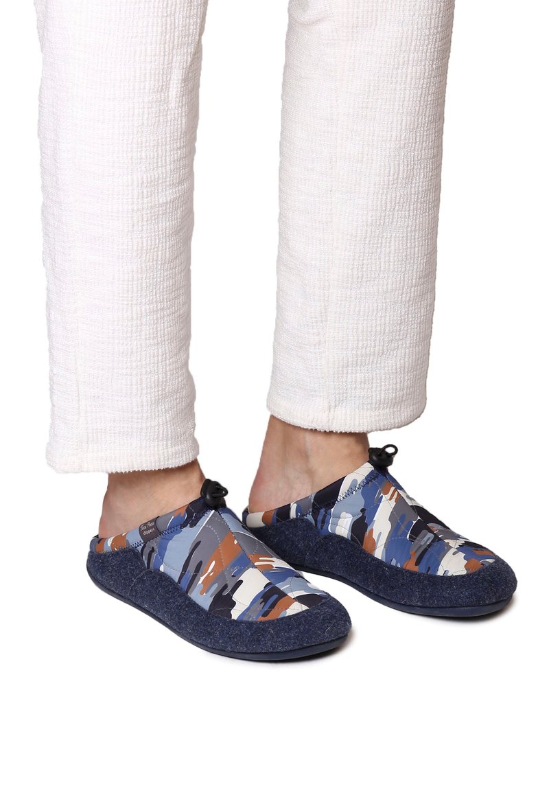 Flerfärgade slip-on skor med abstrakta mönster i blått, beige och orange. Mjuk textilöverdel och mörk, texturerad gummisula.