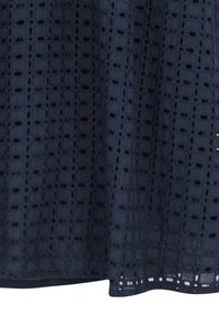 Tissu bleu marine avec un motif en dentelle à œillets carrés et une doublure unie en dessous.