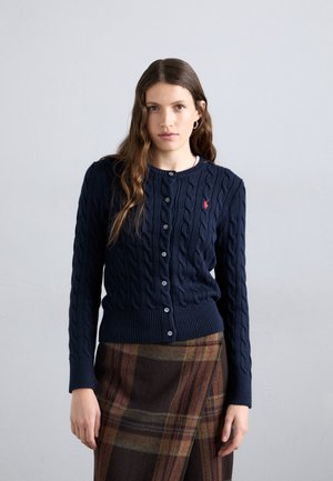 Navy blue cable-knit cardigan with ribbed cuffs and hem. Features round neckline and five-button closure. Red logo accent on chest.