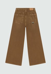 Brune bredbensjeans med en glat tekstur, der har to baglommer og en trekantet detalje på den højre lomme. Forstærket syning.