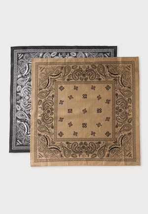 Dos bandanas cuadradas, una beige y otra negra, ambas con estampados de cachemira y la palabra "HUGO" impresa en negro o blanco.
