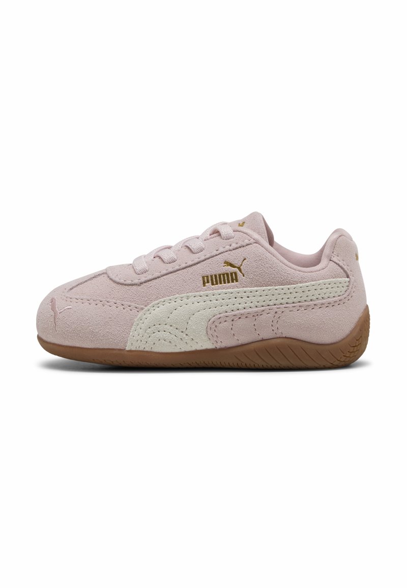 Zapatillas de ante rosa claro con acentos en blanco, que presentan una franja lateral texturizada, diseño con cordones y una suela de goma marrón.