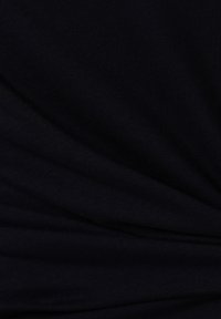 Czarna tkanina o gładkiej, lekko teksturowanej powierzchni. Posiada subtelne fałdy i drapowania, wskazujące na miękki, elastyczny materiał.