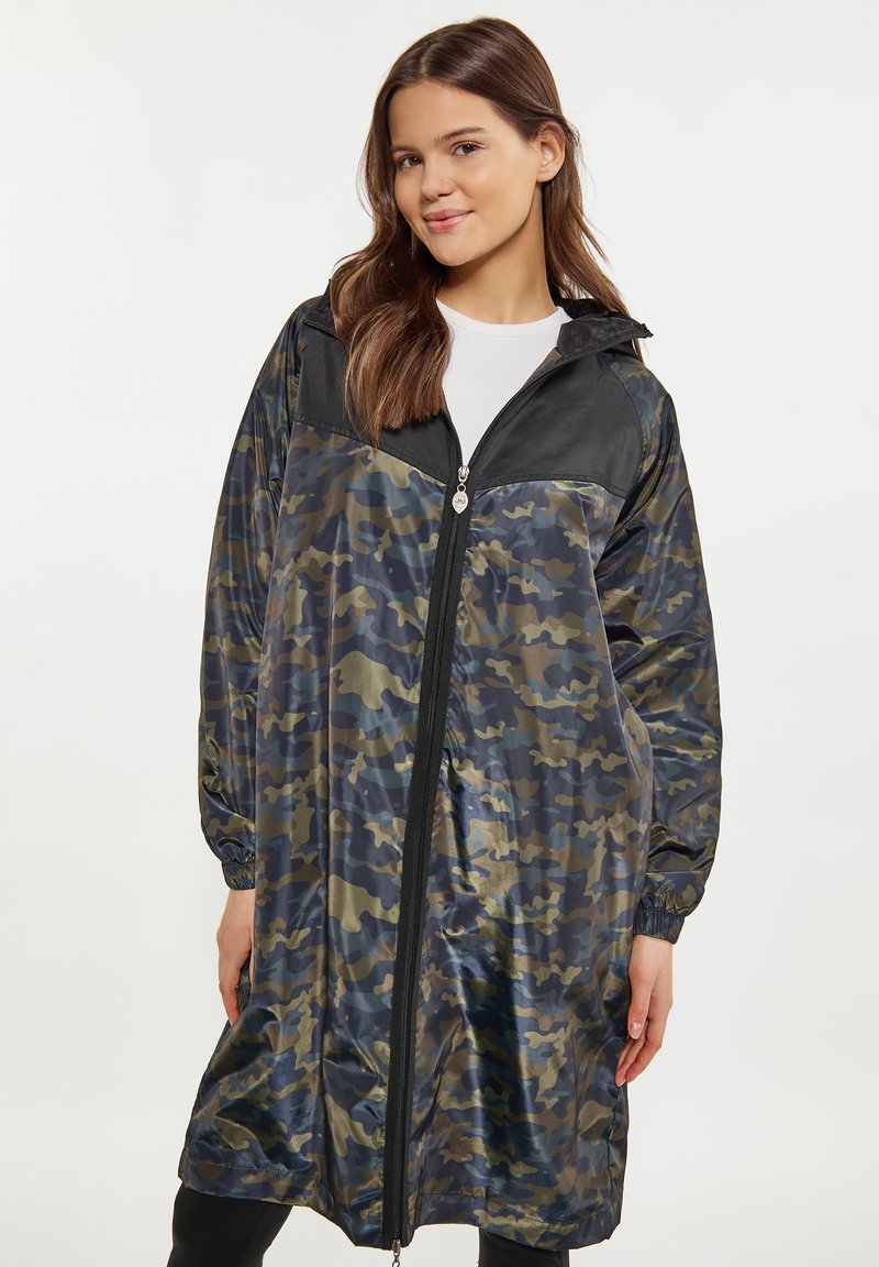Camouflage regenjas met een glanzende afwerking, zwarte accenten, volledige ritssluiting aan de voorkant en elastische manchetten, ontworpen voor een losse pasvorm.