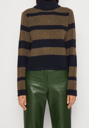 Gestreifter Turtleneck-Pullover in Braun und Marineblau aus weichem Material, mit verkürztem Design und langen Ärmeln. Kombiniert mit glänzenden grünen Lederhosen.
